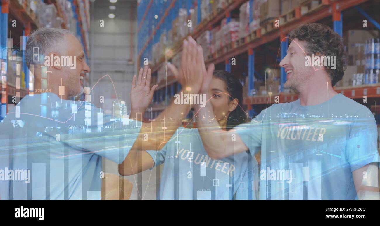 Statistical data processing over male and female volunteers high fiving each other at warehouse Stock Photo