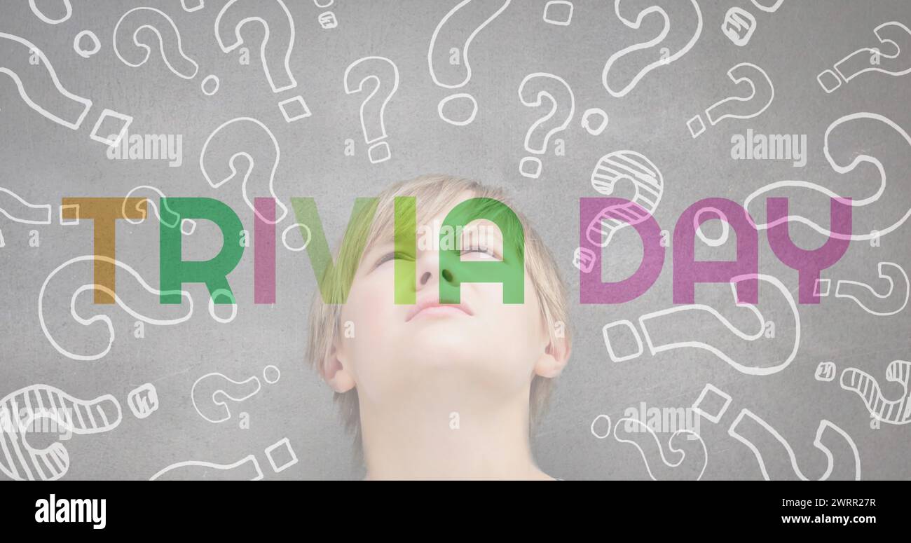 Trivia day text banner against multiple question mark symbols over caucasian boy Stock Photo