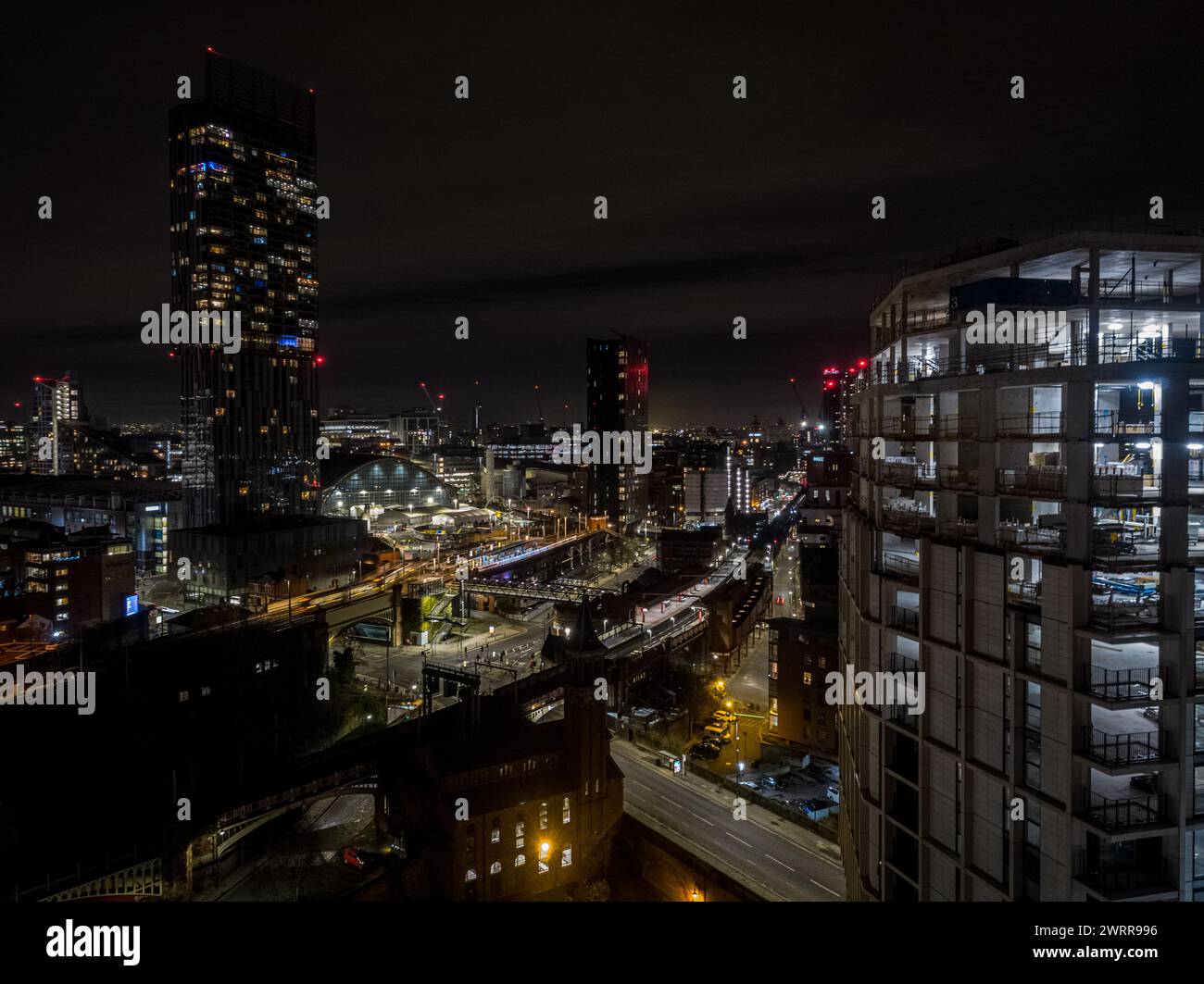 Night time aerial view of the concrete frame of Castle Wharf development under construction and Beetham Tower in Manchester city centre, UK Stock Photo