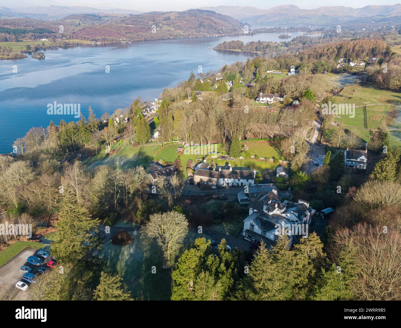 Aerial photograph of  houses in the foreground and Lake Windermere, Cumbria, UK with the Lake District's hills and mountains in the distance Stock Photo