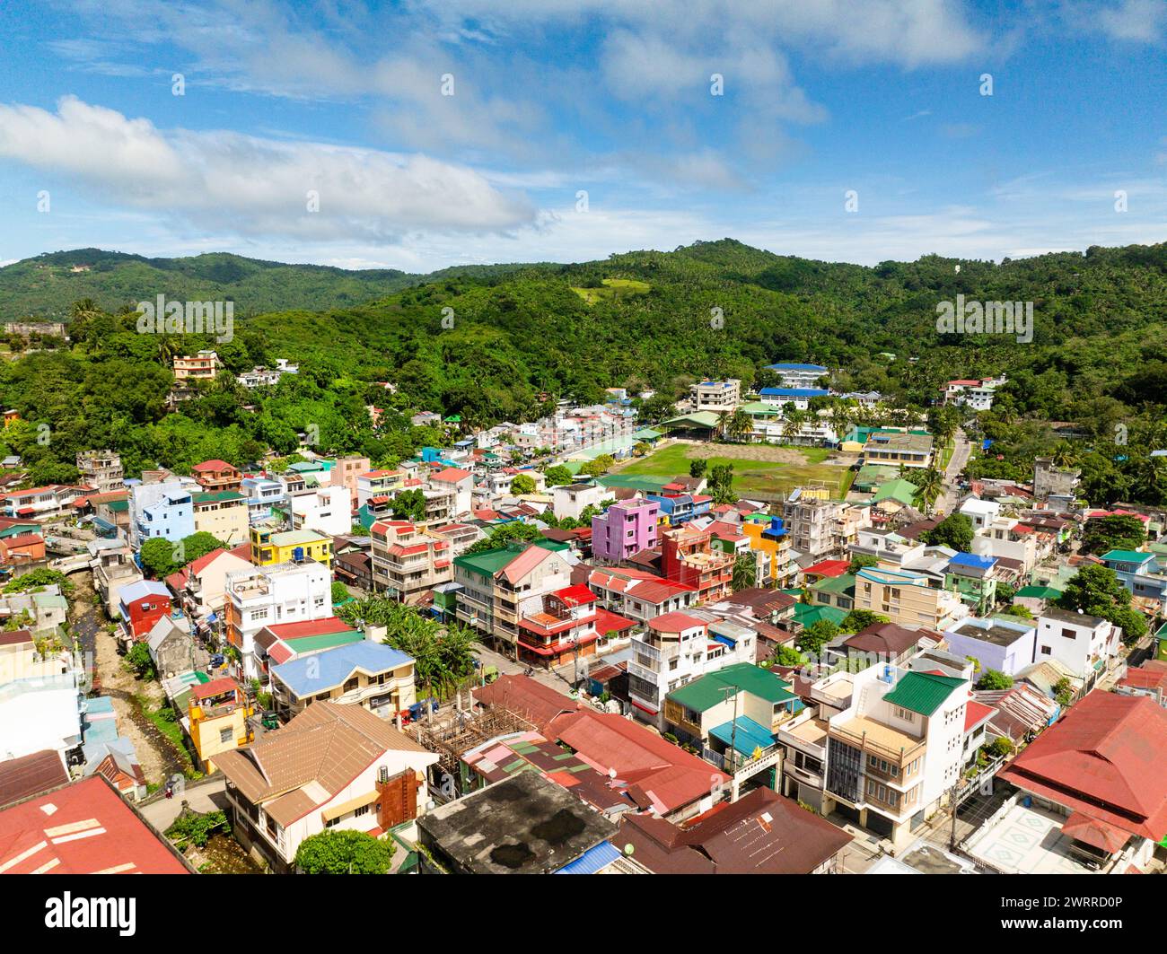 Drone view of residential buildings in downtown near mountain in Romblon Island, Romblon, Philippines. Stock Photo