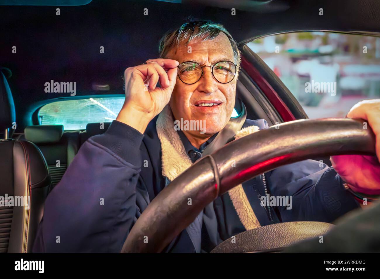 älterer Autofahrer, Ü60, Symbol Fahrtauglichkeit von Senioren, Sehprobleme, März 2024 Deutschland, München, März 2024, älterer Autofahrer, Ü60, am Steuer, Mann schaut angestrengt auf den Verkehr vor ihm, Symbolfoto, EU hat vorgeschlagen, die Fahrtauglichkeit älterer Autofahrer regelmäßig zu überprüfen, verpflichtende Gesundheitschecks einzuführen, Sehstärke, Augenprobleme, Sehschwierigkeiten, Sicht, Blendung, blenden, Stress, Senioren, Unfallgefahr, Führerschein, Licht, Boomer, Babyboomer, *** older driver, over 60, symbol driving fitness of seniors, vision problems, March 2024 Germany, Munich Stock Photo