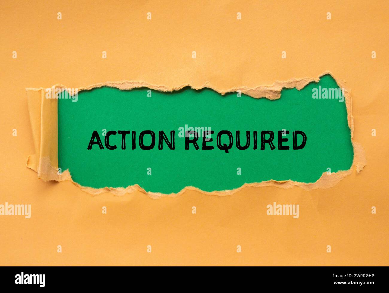 Action required words written on orange torn paper with green background. Conceptual symbol. Copy space. Stock Photo
