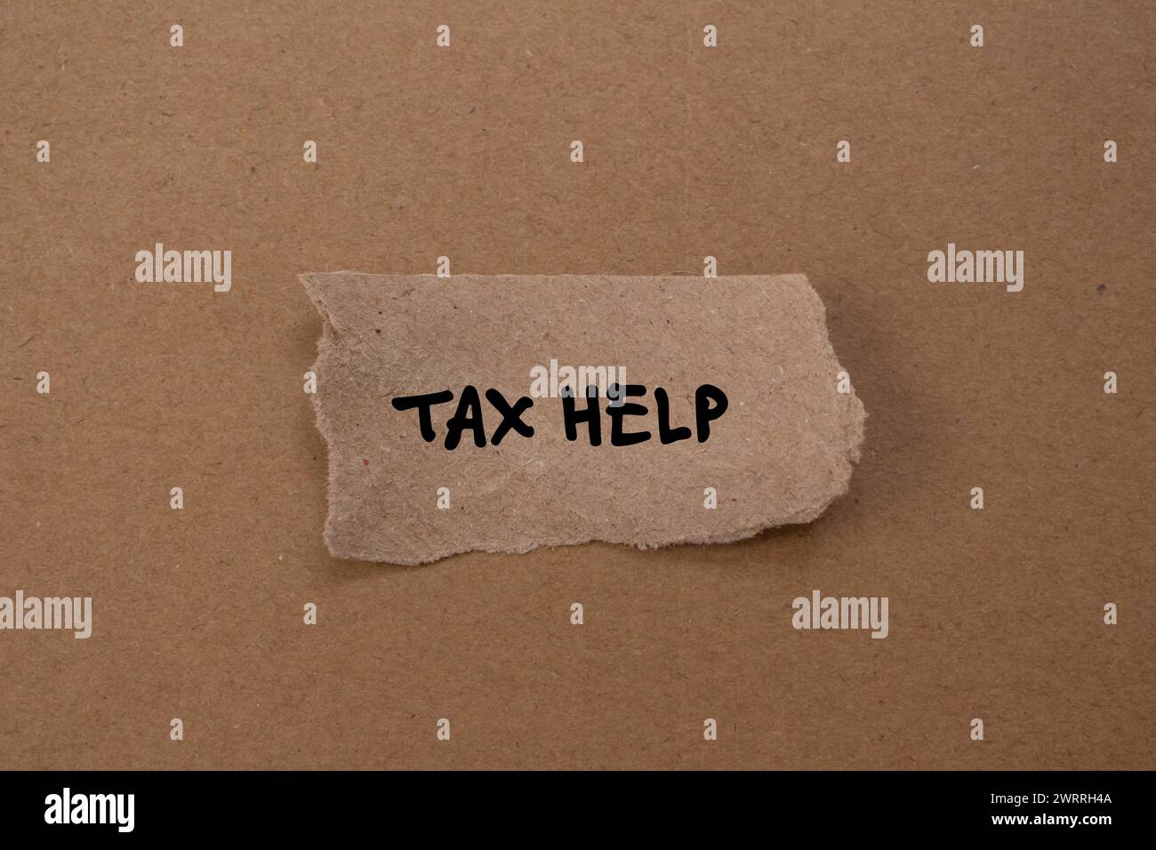 Tax help words written on torn paper piece with brown background ...
