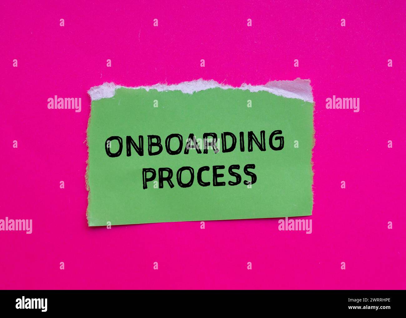 Onboarding process words written on green torn paper with pink background. Conceptual business symbol. Copy space. Stock Photo
