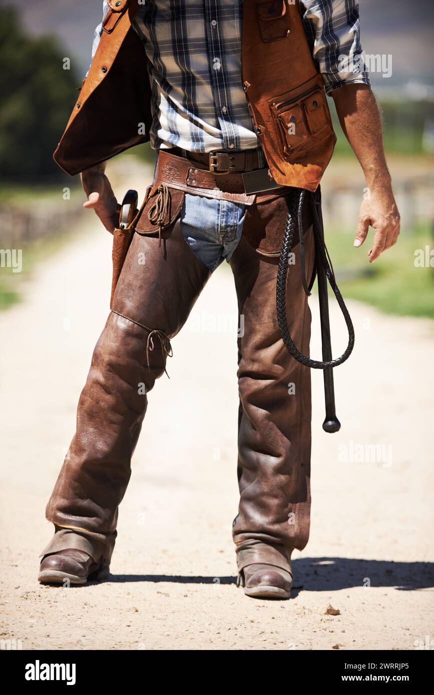 Person, outdoors and gun ready to shoot for standoff or gunfight in duel for wild western culture in Texas. Cowboy gunslinger or outlaw, revolver and Stock Photo