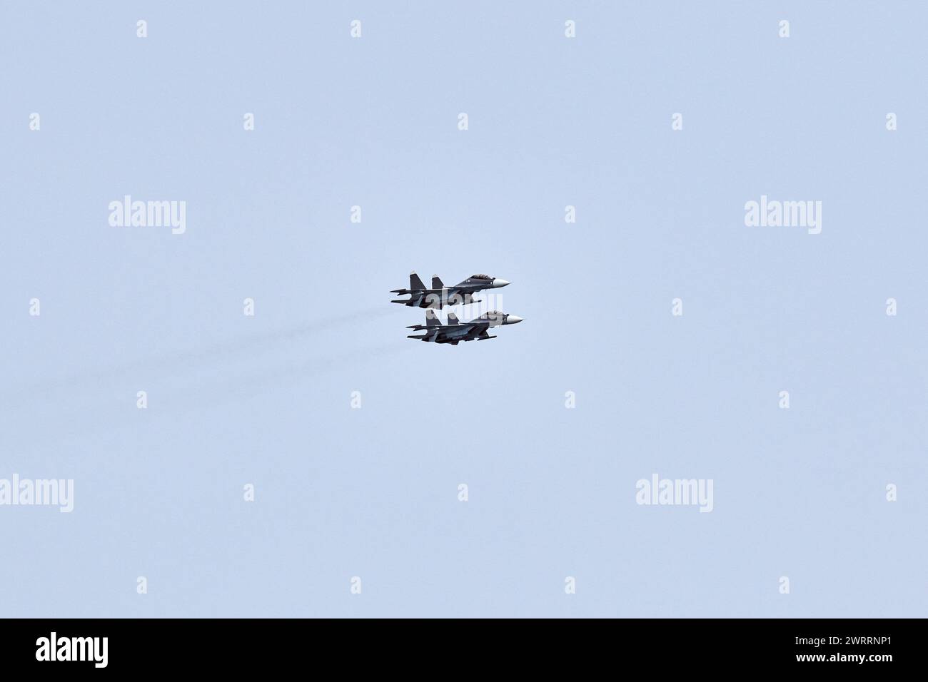 Two Russian military fighter planes armed with missiles flies in blue ...