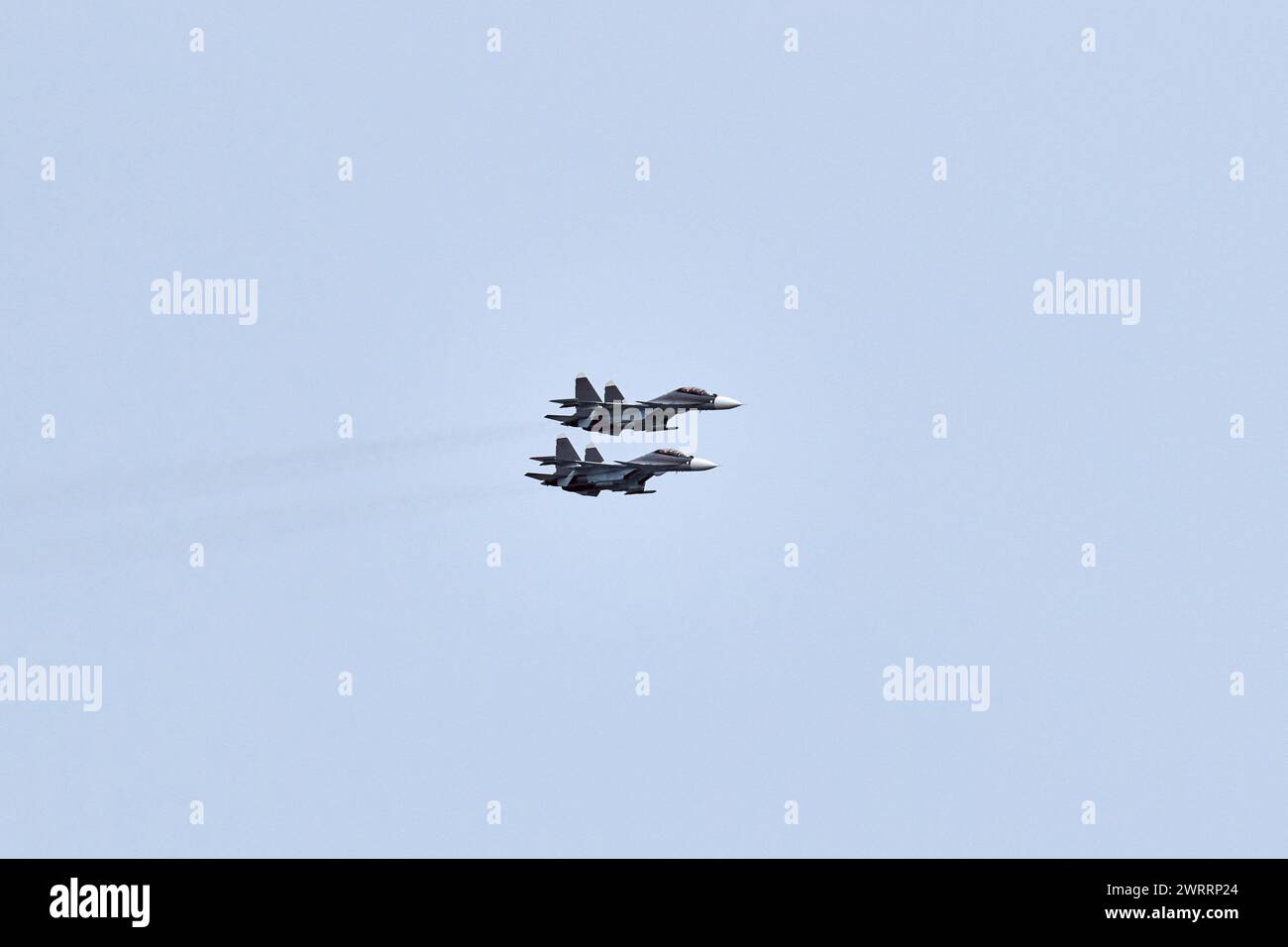 Two Russian military fighter planes armed with missiles flies in blue ...