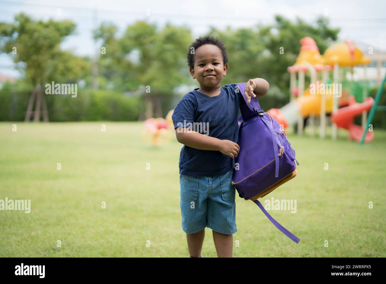 Cute little boy carrying a school bag with a smiling face waiting to go ...