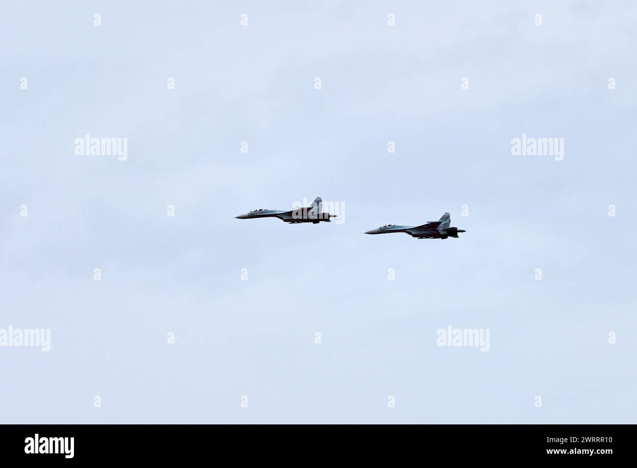Two Russian military fighter planes armed with missiles flies in blue ...