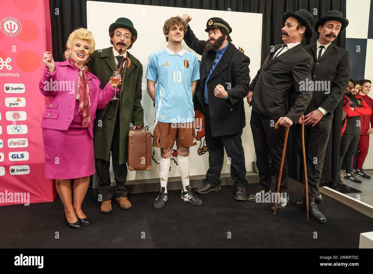 A model showing the away outfit referencing to Kuifje-Tintin, is surrounded by characters from the comic book series, such as singer Bianca Castafiore, Professor Calculus (Tournesol-Zonnebloem), Captain Haddock and detectives Thomson and Thompson (Jansen en Janssen - Dupont et Dupond) during a press conference of Belgian national soccer team Red Devils to present the new shirts for the UEFA Euro 2024 European Championship, Thursday 14 March 2024, at the Musee Herge in Louvain-la-Neuve. The new outfit, with light blue shirt with white collar, combined with brown shorts, refers to the iconic out Stock Photo