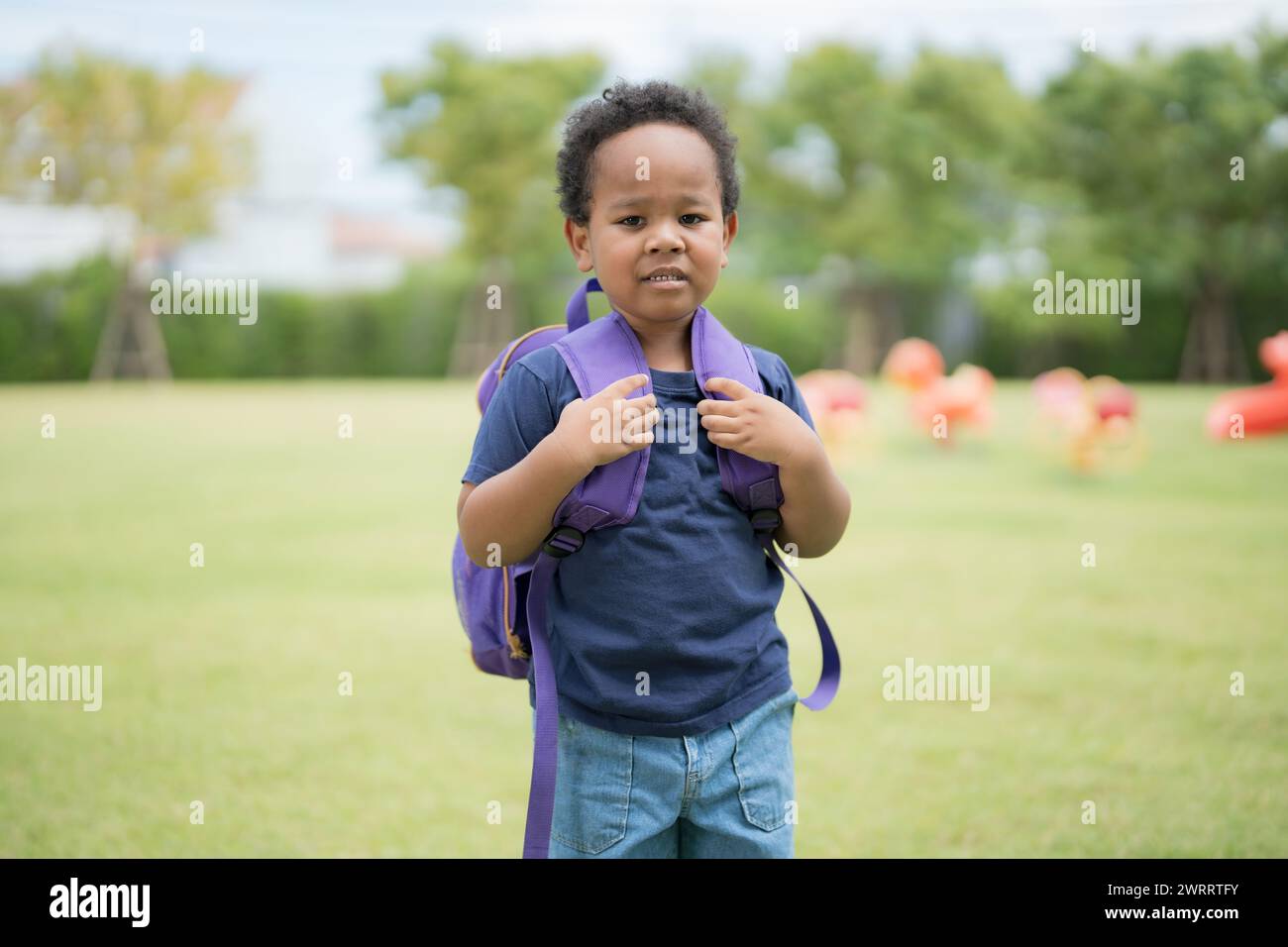 Cute little boy carrying a school bag with a smiling face waiting to go ...
