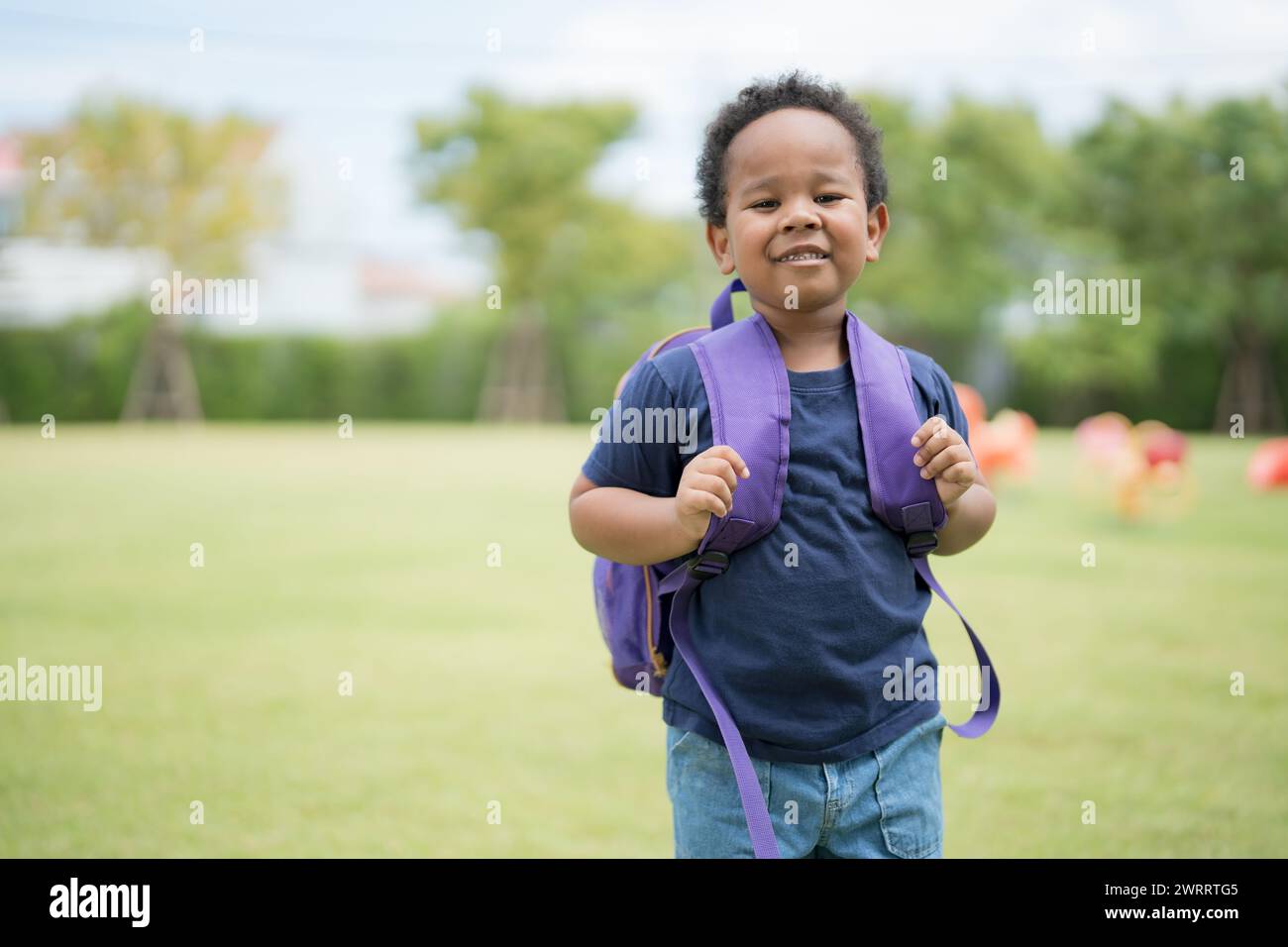 Cute little boy carrying a school bag with a smiling face waiting to go ...