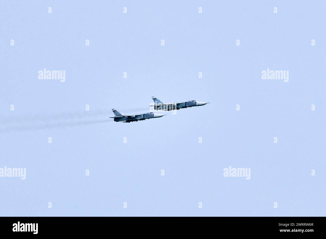 Two Russian military fighter planes armed with missiles flies in blue ...