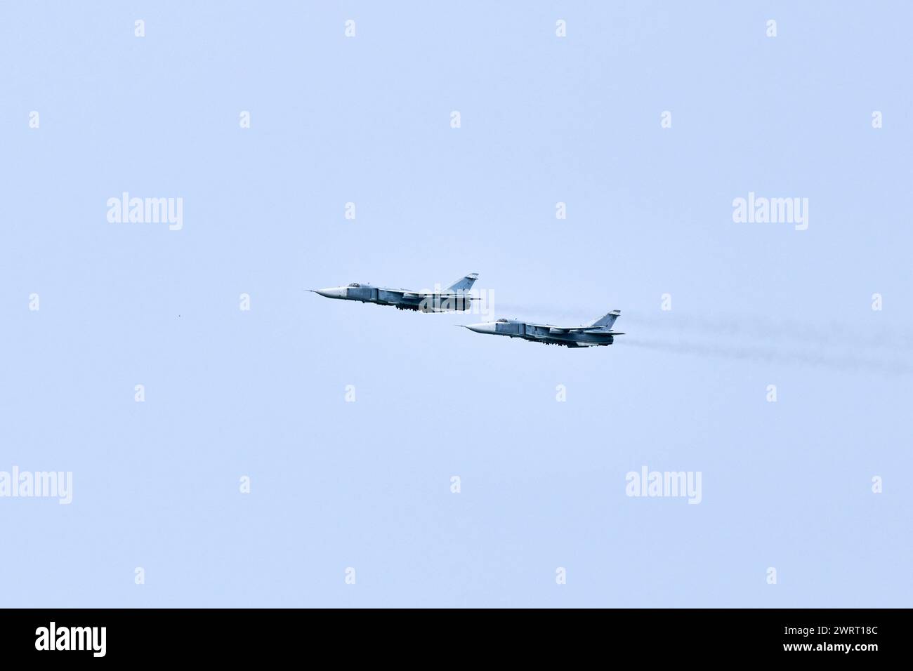 Two Russian military fighter planes armed with missiles flies in blue ...