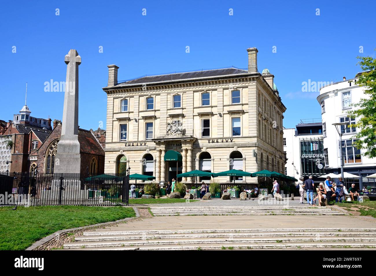 View of The Ivy Bistro and St Pentrock church along Cathedral Yard with a war memorial in the foreground, Exeter, Devon, UK, Europe. Stock Photo