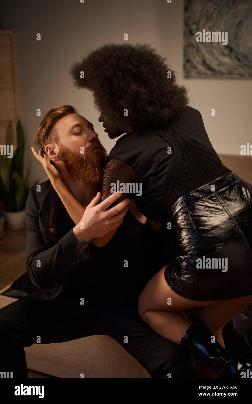 passionate night of diverse couple in intimate setting, african american woman kissing tattooed man Stock Photo