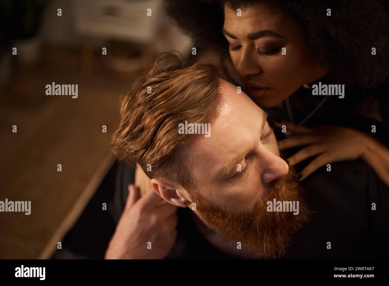 passionate night of diverse couple at home, curly african american woman kissing tattooed man Stock Photo