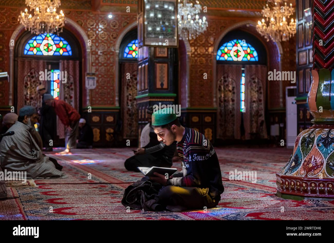 A Kashmiri Muslim man reads from the Islamic holy book Quran inside a ...