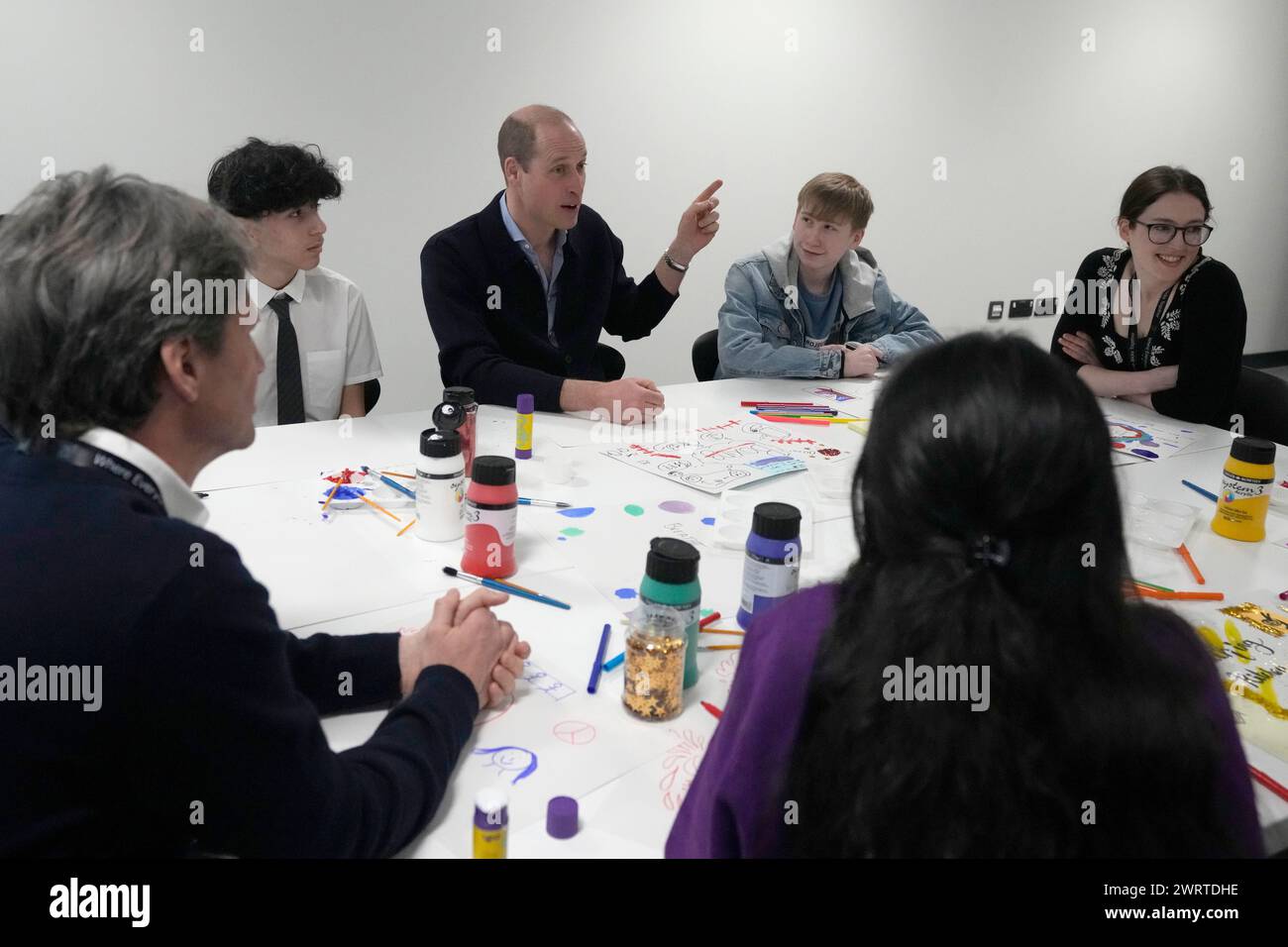 Prince William gestures as he interacts with young people during his