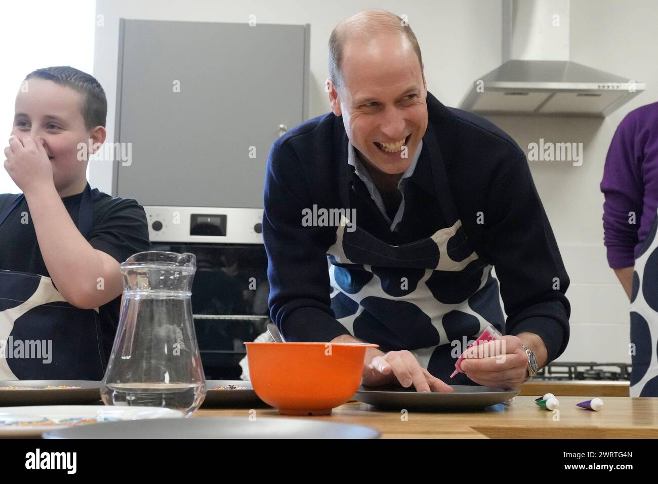 The Prince of Wales decorates biscuits during a visit to WEST, the new