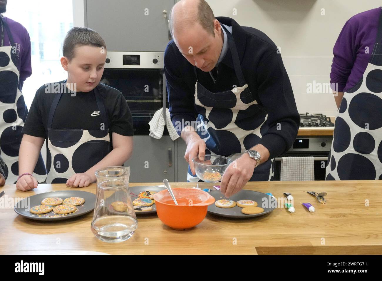 The Prince of Wales decorates biscuits during a visit to WEST, the new