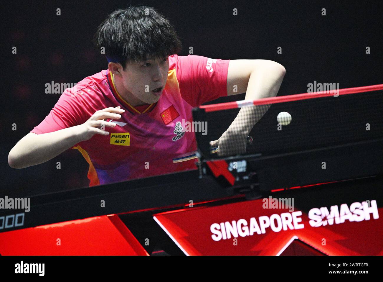 Singapore. 14th Mar, 2024. Wang Chuqin of China hits a return during