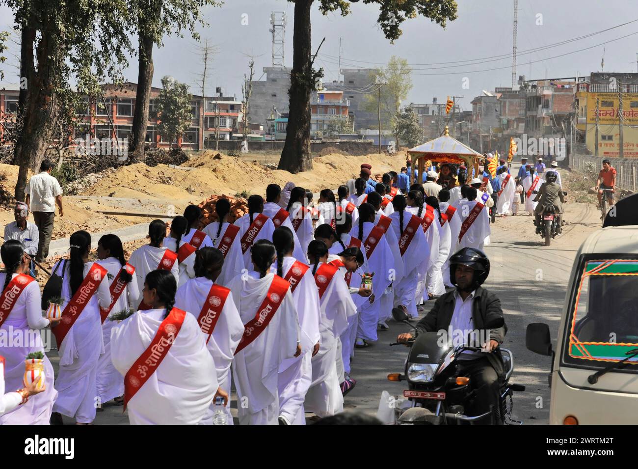 People in traditional dress marching in an urban environment, Bhairahawa, Nepal Stock Photo