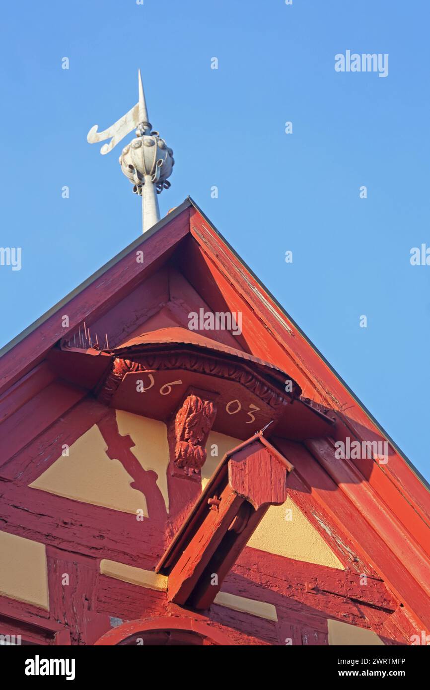 Red gable with crane dormer, year 1603 and weather vane from Hotel Eisenhut, roof ridge, detail, half-timbered house, view upwards, red, market Stock Photo