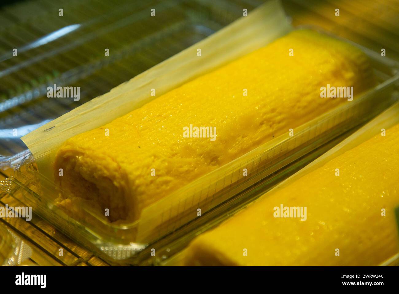 Tamago  is a Japanese omelet. It's made by rolling together thin layers of fried eggs, then slicing the log into rectangles. Stock Photo