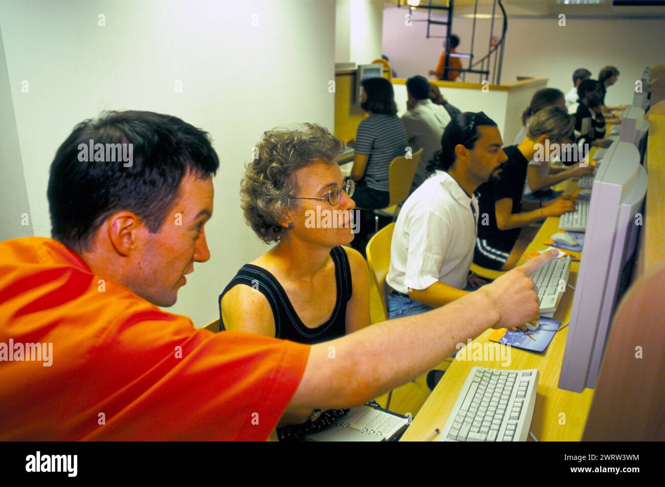 Internet cafe 1990s UK.  Woman being shown how the www works by an assistant. There are 400 terminals in this Internet Café run by the Easy Everything, Easy Group . Victoria London England 1999 HOMER SYKES Stock Photo