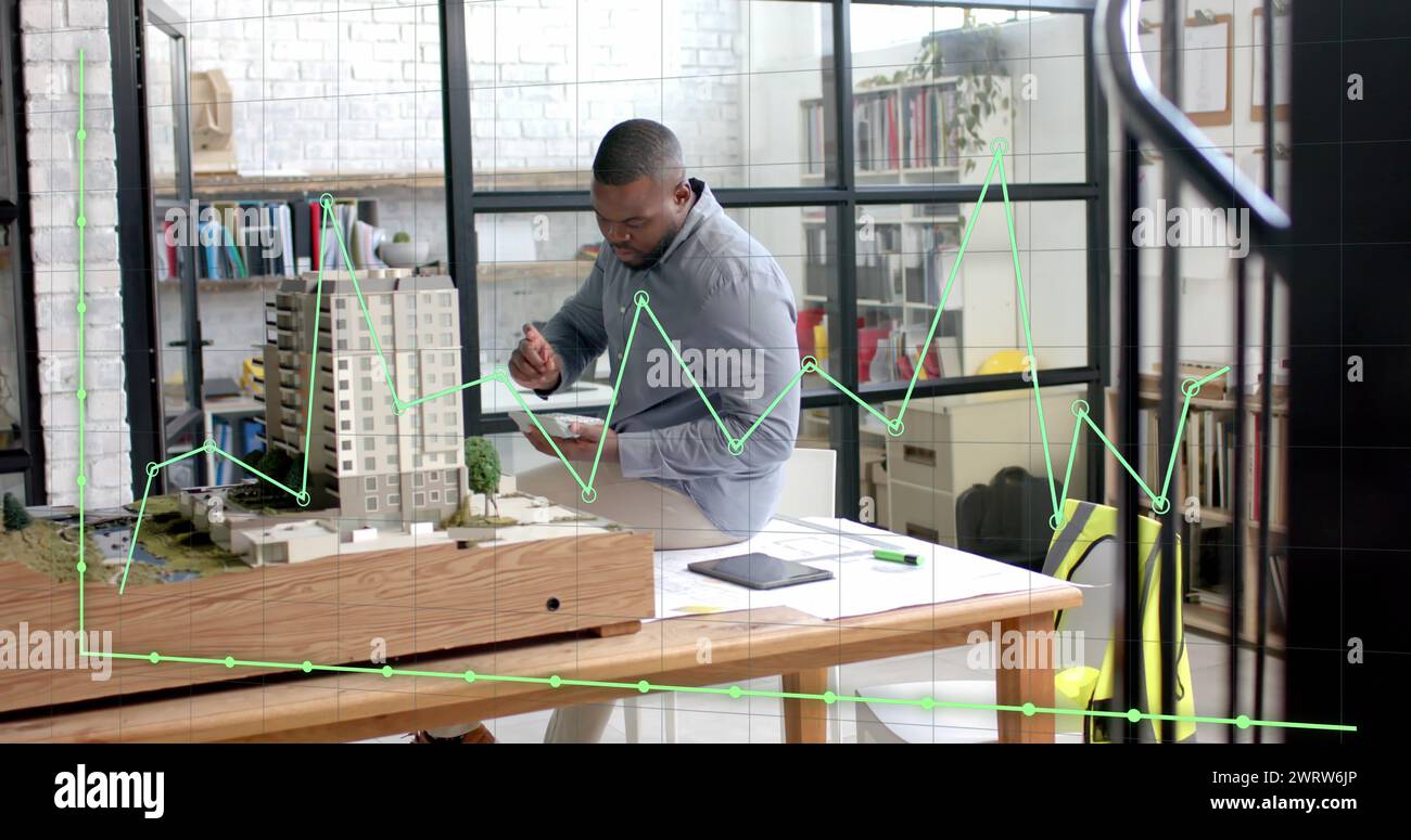 Data processing on graph over african american male architect studying building model Stock Photo