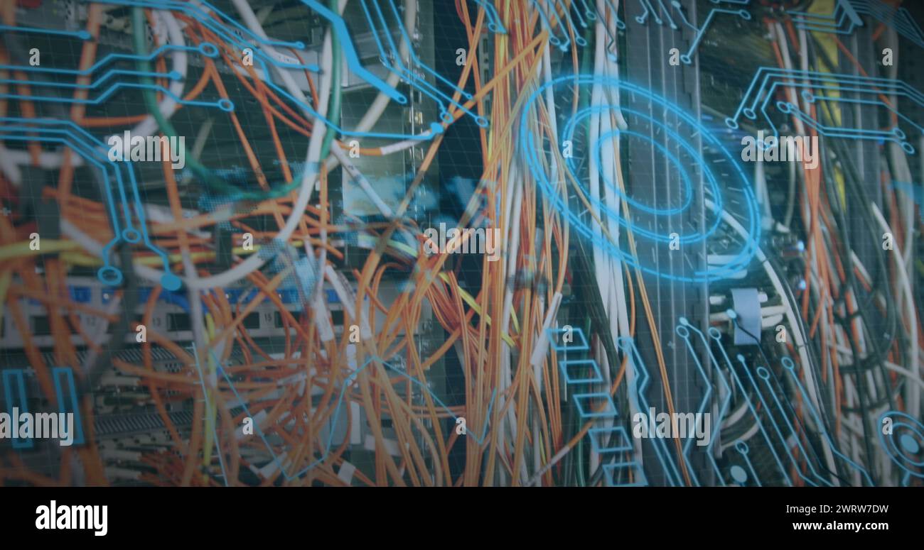 Circuit board patterns and wires create a complex backdrop Stock Photo