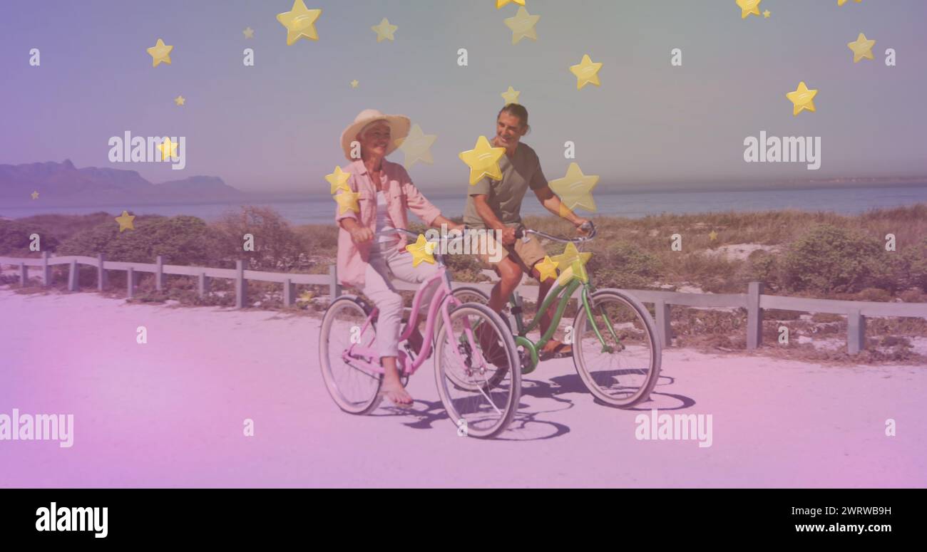 Multiple golden star icons against caucasian senior couple riding bicycles together at the beach Stock Photo