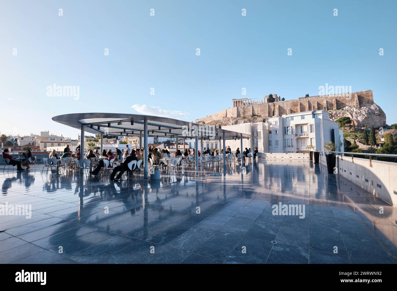 Athens, Greece - March 03, 2024: Restaurant at Acropolis museum with opened terrace and Parthenon view full of customers on sunny day in Greece Stock Photo