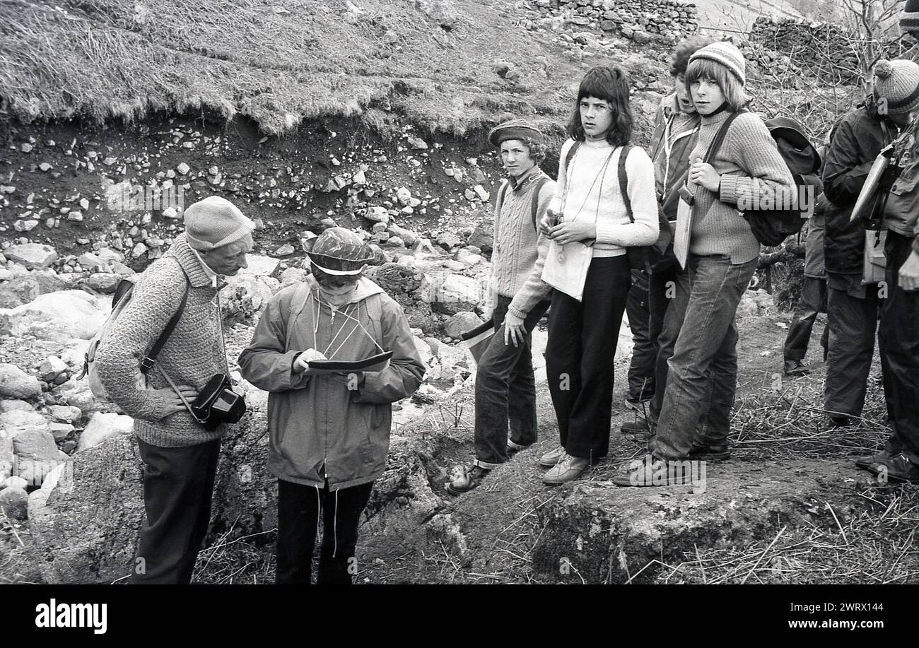 1970s, historical, young people, one studying a map with an instructor, out on an outward bound course, Ambleside, Lake District, Cumbria, England, UK. Outward bound courses help young people build resilience as they take on new challenges and learn leadership and teamwork skills. Stock Photo