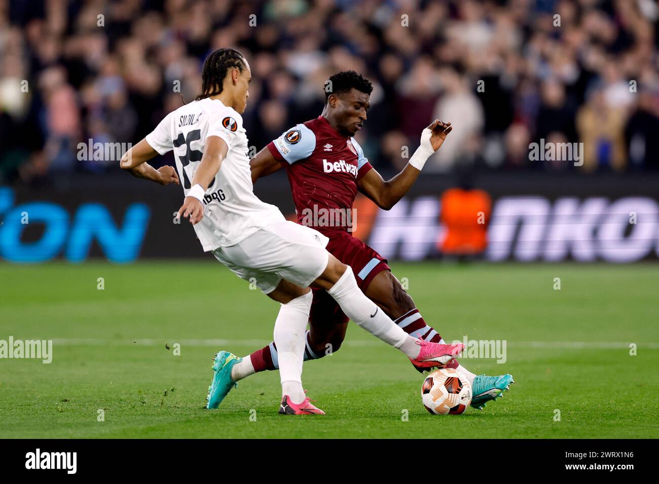 West Ham United's Mohammed Kudus (right) battle for the ball with SC Freiburg’s Kiliann Sildillia during the UEFA Europa League Round of 16, second leg match at the London Stadium, London. Picture date: Thursday March 14, 2024. Stock Photo