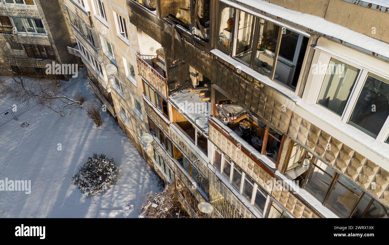 Drone photography of a few burned up apartments in in multistory houses and iced up windows during sunny winter day Stock Photo