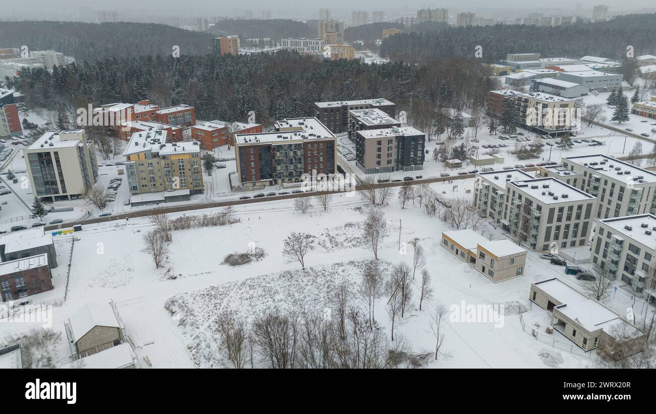 Drone photography of a city landscape, buildings, public parks covered in snow during winter cloudy day Stock Photo