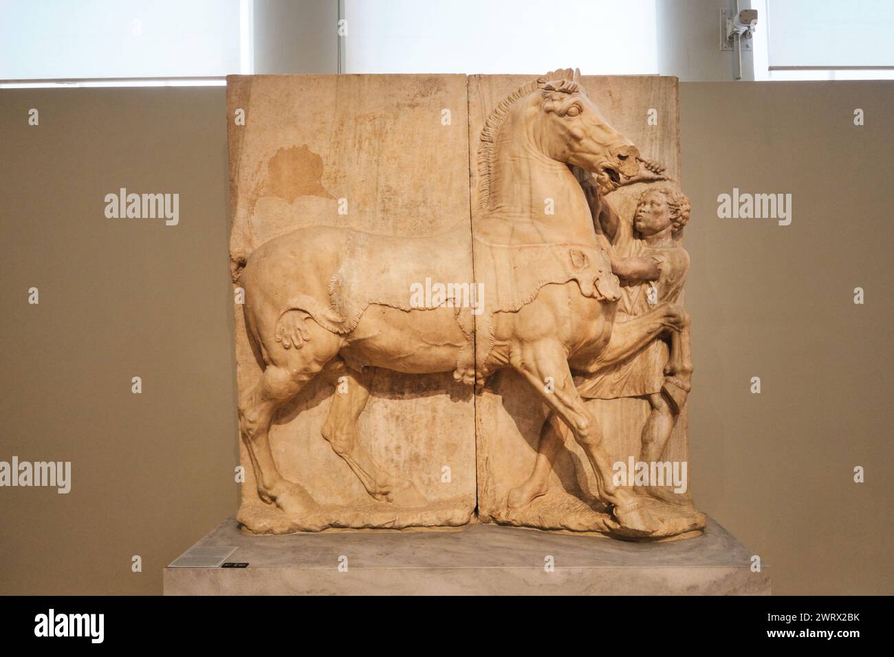 Athens, Greece - March 03, 2024: Grave stele depicting a horse and its Ethiopian groom (4th cent. B.C.) at the National Archaeological Museum Stock Photo