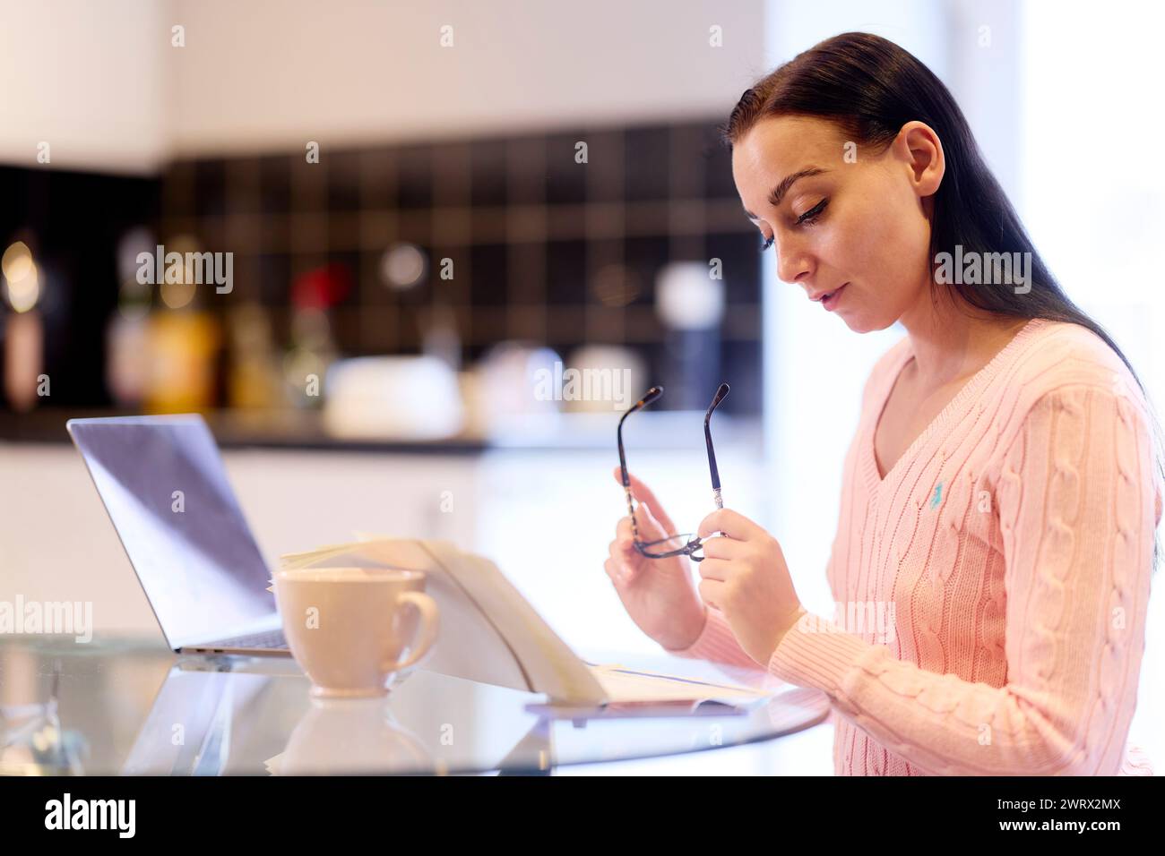 Woman looking through her finances at home Stock Photo