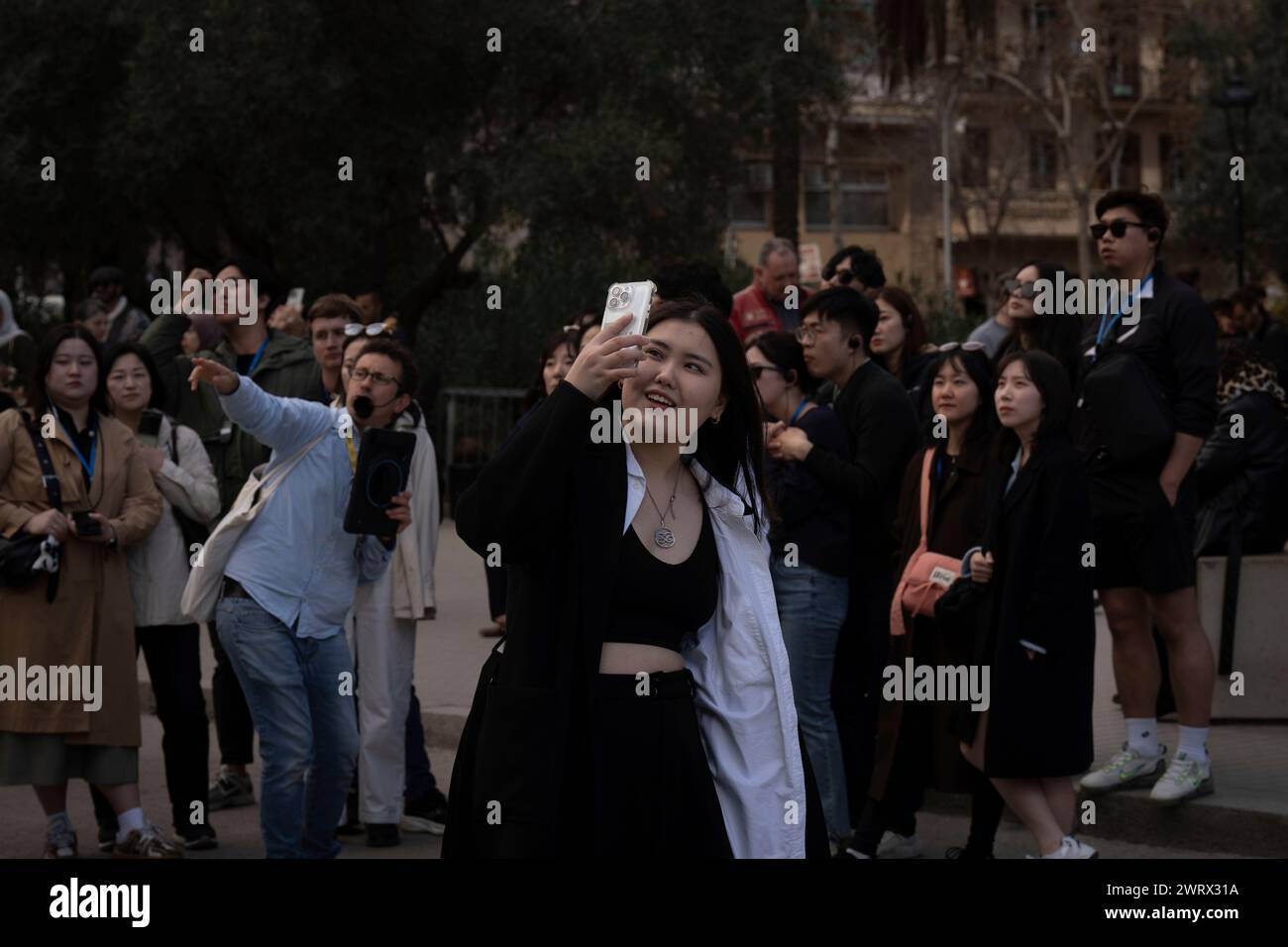 Tourists take pictures next to the Sagrada Familia on March 15, 2024 ...