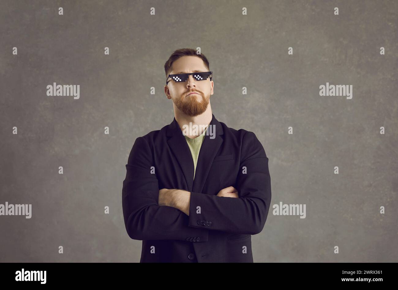 Portrait of a funny and cool, proud and arrogant man with pixel glasses on a gray background. Stock Photo