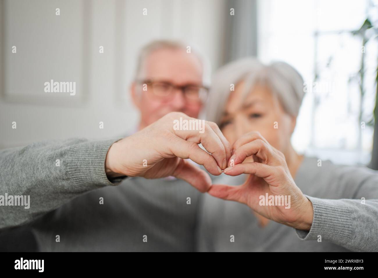 Love heart shape peace. Senior older couple making heart shape with ...