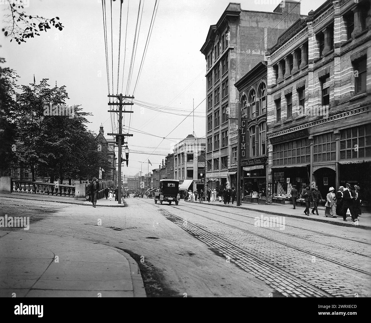 Vintage Street Photography of downtown Halifax Nova Scotia, Canada.  Barrington Street, 1915.  With car driving down cobbled stone on this commercial street.  photo by Wm. Notman & Son Stock Photo