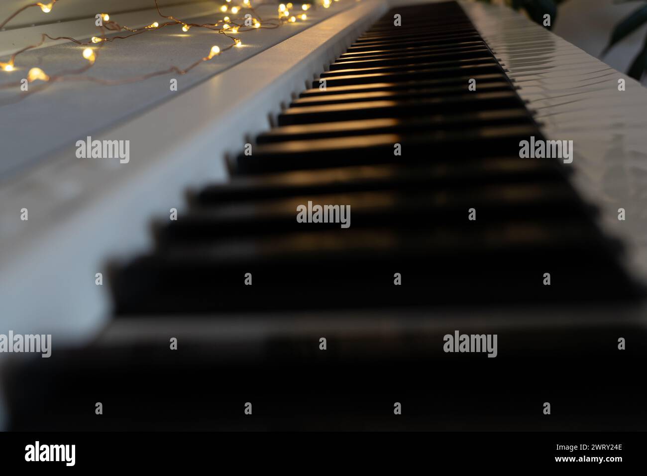 Close up piano keys lit with fairy lights. High quality photo Stock Photo