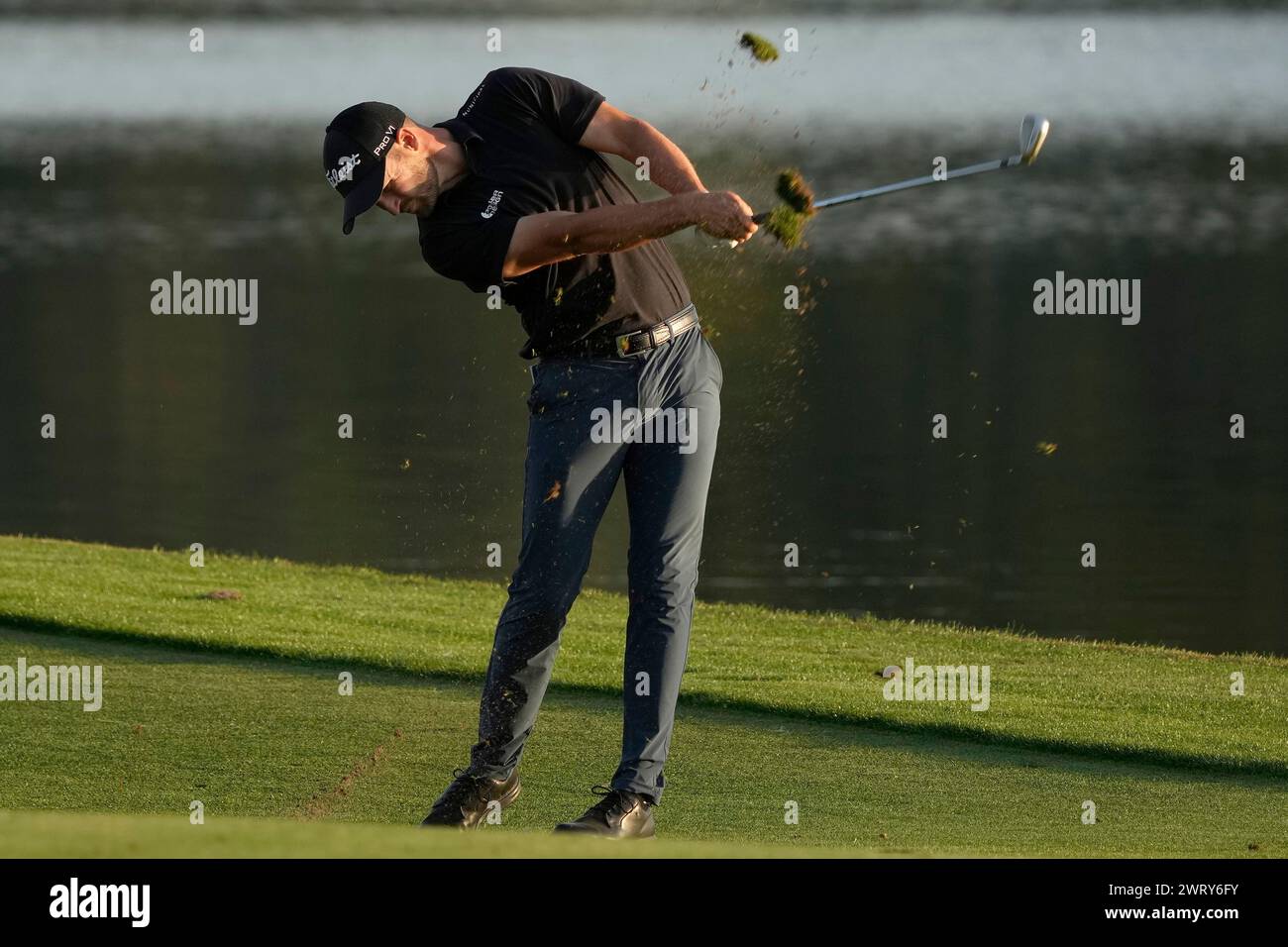 Wyndham Clark takes a divot as he hits from the 18th fairway during the