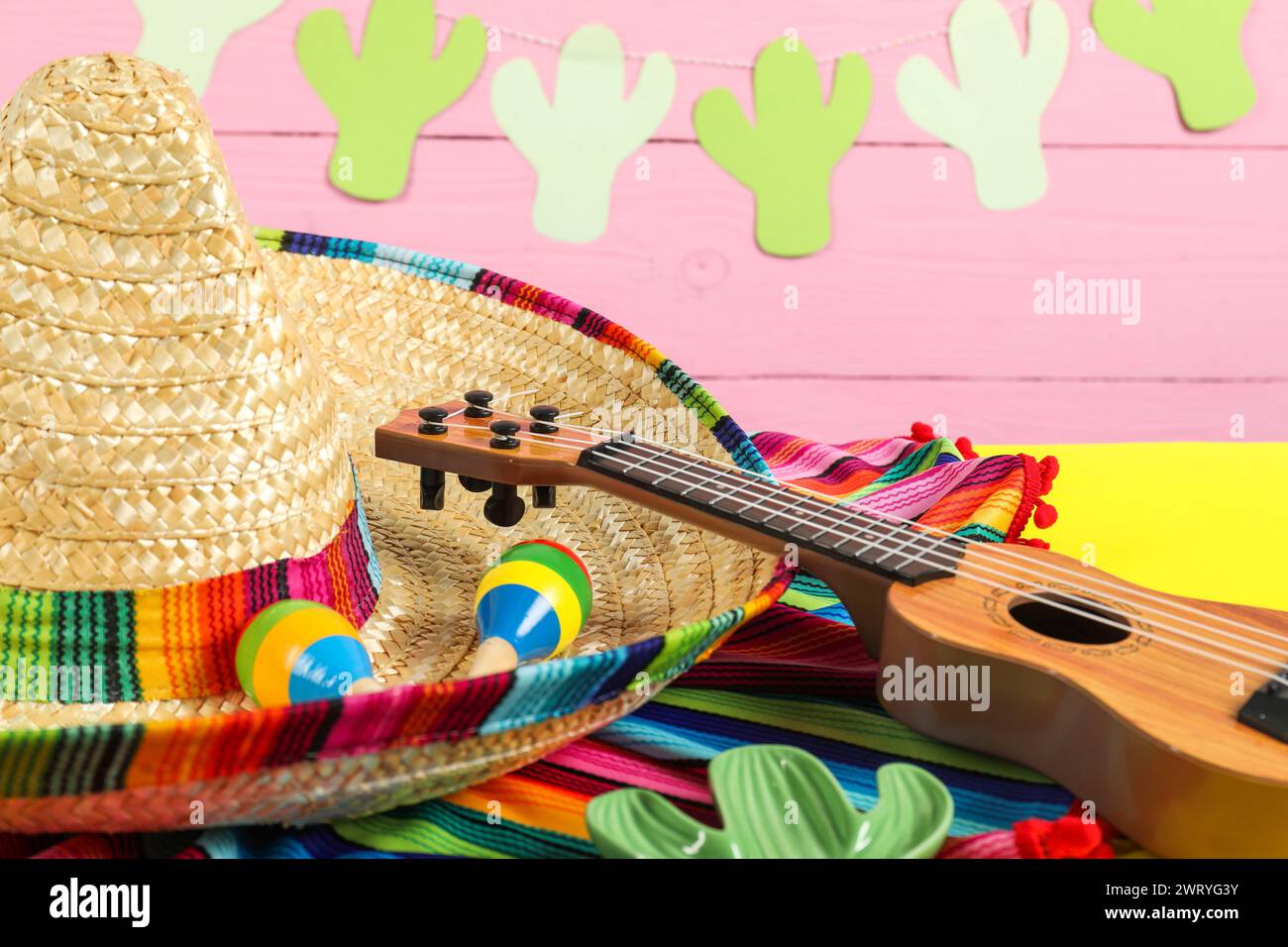 Mexican sombrero hat ukulele and maracas on yellow table closeup Stock Photo Alamy