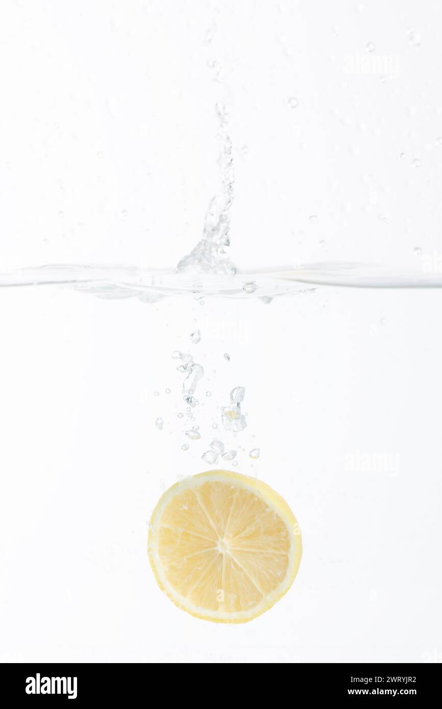half of a lemon falling into the water Stock Photo