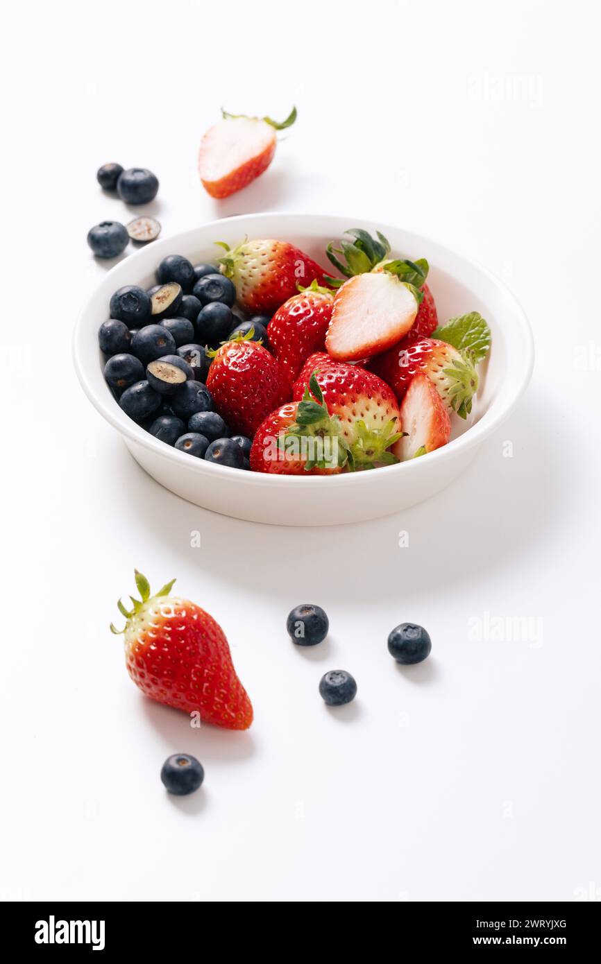 Blueberries and strawberries on a white plate Stock Photo